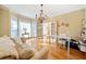 Bright office with hardwood floors, large windows, chandelier, and a comfortable seating area at 217 Colonial Dr, Woodstock, GA 30189