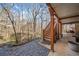 Covered patio with stone pathway to a wooded view and dining underneath the deck at 217 Colonial Dr, Woodstock, GA 30189