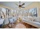 Relaxing sunroom with wood floors, lots of windows, ceiling fan and comfortable daybed at 217 Colonial Dr, Woodstock, GA 30189