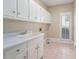 Functional laundry room with cabinetry, sink, and natural light at 370 Royal Birkdale Ct, Duluth, GA 30097