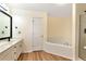 Bright bathroom featuring double sinks, a corner soaking tub, and modern fixtures at 386 Creek Manor Way, Suwanee, GA 30024