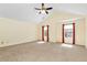 Spacious bedroom with neutral carpet, ceiling fan, and natural light streaming through the two windows at 386 Creek Manor Way, Suwanee, GA 30024