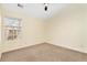 Bedroom with neutral walls, carpet, ceiling fan, and a large window providing natural light at 386 Creek Manor Way, Suwanee, GA 30024