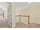 Upstairs hallway with wooden railing and neutral carpet leading to bedrooms, creating a cohesive design at 386 Creek Manor Way, Suwanee, GA 30024