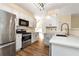 Well-lit kitchen features stainless steel appliances, white cabinets, and stone countertops for a modern feel at 386 Creek Manor Way, Suwanee, GA 30024