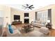 Furnished living room with a fireplace, neutral tones, and a ceiling fan offering a comfortable and stylish space at 386 Creek Manor Way, Suwanee, GA 30024