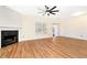 Bright living room featuring a fireplace, a modern fan, and laminate flooring, creating a cozy atmosphere at 386 Creek Manor Way, Suwanee, GA 30024