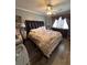 Comfortable bedroom featuring a large bed, ceiling fan, and wooden floors at 6163 Princeton Ave, Morrow, GA 30260