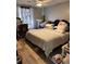 A simple bedroom includes a neatly made bed, curtains, and hardwood floors at 6163 Princeton Ave, Morrow, GA 30260