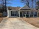 Inviting single-story home featuring green shutters, well-maintained landscaping, and a spacious driveway at 6163 Princeton Ave, Morrow, GA 30260