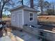 A simple shed features a door and window with a brick foundation at 6163 Princeton Ave, Morrow, GA 30260