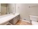 Neutral bathroom features a long vanity, large mirror, and marble-look flooring at 98 Pace Dr, Hiram, GA 30141