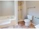 Neutral bathroom with large tub, stand up shower, and marble-look flooring at 98 Pace Dr, Hiram, GA 30141