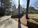 View of the front exterior showing the front lawn and trees with an asphalt driveway at 98 Pace Dr, Hiram, GA 30141