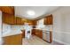 This kitchen offers wood cabinets, white appliances, laminate flooring, and lots of natural light at 98 Pace Dr, Hiram, GA 30141