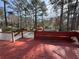 Red wooden deck overlooking the backyard pool area, complete with an arbor and fence, great for entertaining at 98 Pace Dr, Hiram, GA 30141