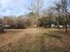 Spacious backyard featuring a mix of grass, bare ground, and mature trees enhancing privacy at 1619 Flowery Branch Rd, Auburn, GA 30011