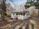 Cozy cottage with a welcoming porch and neutral tones set amongst beautiful trees at 1619 Flowery Branch Rd, Auburn, GA 30011