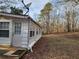 Side view of cottage exterior with white siding, multiple windows, and a satellite dish at 1619 Flowery Branch Rd, Auburn, GA 30011