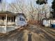 Side view of the home showing white siding, a small porch, and a detached shed in the background at 1619 Flowery Branch Rd, Auburn, GA 30011