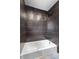 Updated bathroom featuring black tile, a showerhead, and a white tub at 260 Sandy Lake Cir, Fayetteville, GA 30214