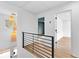 Bright hallway featuring modern railing, light wood flooring, and stylish pendant lights at 260 Sandy Lake Cir, Fayetteville, GA 30214