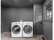 Gray painted laundry room featuring a tile floor and modern washer and dryer at 260 Sandy Lake Cir, Fayetteville, GA 30214