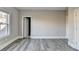 Bedroom featuring wood-look flooring, neutral walls and trim, a window, and a doorway at 3540 Paddocks Pkwy, Suwanee, GA 30024