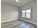 Cozy bedroom with a large window allowing for ample natural light and stylish gray wood flooring at 3540 Paddocks Pkwy, Suwanee, GA 30024