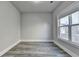 Bright bedroom featuring stylish gray wood flooring and a large window for plenty of natural light at 3540 Paddocks Pkwy, Suwanee, GA 30024