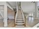 A grand entryway boasts a staircase leading up to the second floor and light wood floors at 3540 Paddocks Pkwy, Suwanee, GA 30024