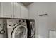 Laundry room featuring a Samsung washer and dryer, and white upper cabinets at 3540 Paddocks Pkwy, Suwanee, GA 30024