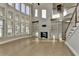 Open-concept living room featuring a fireplace with built-in bookshelves and light wood floors at 3540 Paddocks Pkwy, Suwanee, GA 30024