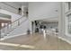 Spacious living room with a staircase to the second floor, light wood floors, and gray walls at 3540 Paddocks Pkwy, Suwanee, GA 30024