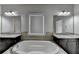 Main Bathroom featuring a stand alone tub, granite countertops, double sinks and tile flooring at 3540 Paddocks Pkwy, Suwanee, GA 30024