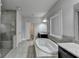 Large Main Bathroom featuring a stand alone tub, glass enclosed shower, granite countertops and tile flooring at 3540 Paddocks Pkwy, Suwanee, GA 30024