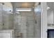 Modern tiled shower with glass door, bench, window, and gray tile and decorative accent tile at 3540 Paddocks Pkwy, Suwanee, GA 30024