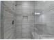 Main Bathroom glass enclosed shower with bench, large shower head and shampoo niche at 3540 Paddocks Pkwy, Suwanee, GA 30024
