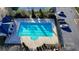 This aerial view shows a community swimming pool with parking and tennis courts in the background at 3540 Paddocks Pkwy, Suwanee, GA 30024