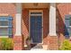 Close-up of a blue front door with brick columns and decorative accents at 403 Sonja Ln, Loganville, GA 30052