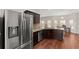 Open kitchen featuring stainless steel appliances, hardwood floors, and a view to the dining area at 403 Sonja Ln, Loganville, GA 30052