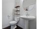Powder room featuring a pedestal sink, round mirror, and three-tiered rope shelf at 921 Ambient Sw Way, Atlanta, GA 30331