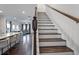 Staircase with dark wood steps, white risers, and an open kitchen and living area at 921 Ambient Sw Way, Atlanta, GA 30331