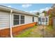 Backyard view of the home featuring a covered porch, brick foundation, and small yard space at 135 Wilbanks Dr, Fayetteville, GA 30215