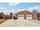 Charming brick home featuring a two-car garage and a well-maintained front yard at 135 Wilbanks Dr, Fayetteville, GA 30215