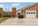 Welcoming front entrance with brick facade, a two-car garage, and manicured greenery at 135 Wilbanks Dr, Fayetteville, GA 30215