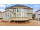 Back of the home with a wooden deck, multiple windows, and beige vinyl siding at 1859 Mapmaker Dr, Dacula, GA 30019