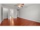 Bright bedroom featuring hardwood floors, ceiling fan, and access to an ensuite bathroom at 1859 Mapmaker Dr, Dacula, GA 30019