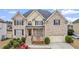 Two story home with a brick front, black shutters, two car garage, and manicured lawn at 1859 Mapmaker Dr, Dacula, GA 30019