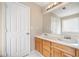 Bathroom featuring a double sink vanity, large mirror, and white door at 4477 James Wade Dr, Snellville, GA 30039
